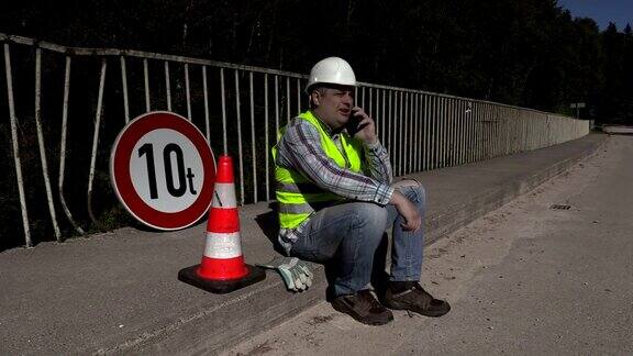 道路建筑工人一边走路一边打电话