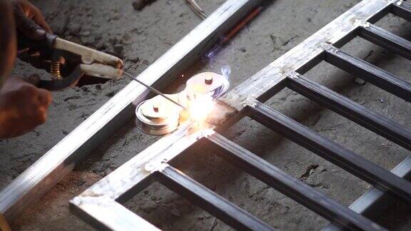 专业工人在工地焊接钢材制作铁门