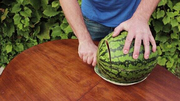 一名男子在盘子上切下一片西瓜