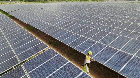 技术工程师穿过太阳能电池板检查太阳能发电厂的太阳能电池板