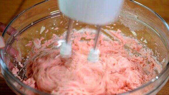 草莓蛋糕用搅拌器搅拌草莓奶油