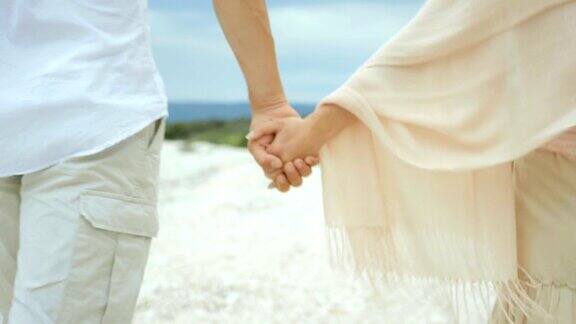 情侣手牵着手在海滩上散步