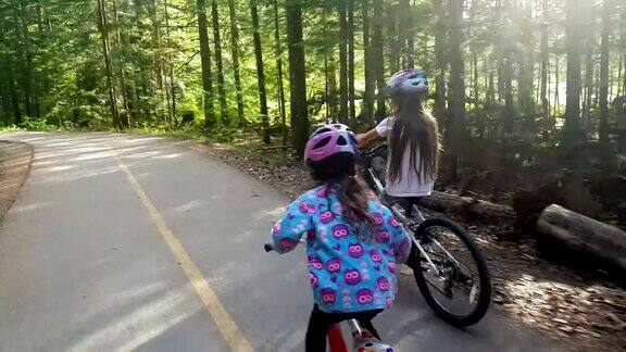 孩子们骑着自行车穿过一片郁郁葱葱的森林