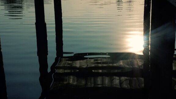 夕阳在河岸上美丽的木桥倒映在水面上连绵不绝的江水和木桥