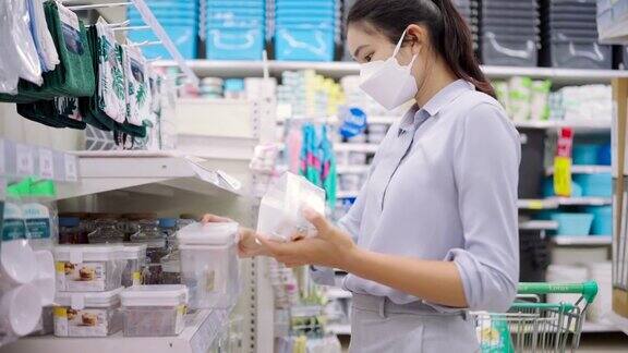 亚洲女孩戴口罩保护她的脸在超市购物