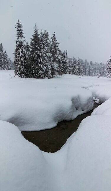 冬天的风景近距离观察从山间流淌的河水融化着深深的白雪背景