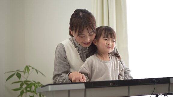 母亲在教孩子练习弹钢琴