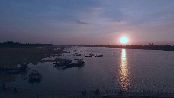 空中:飞回来夕阳下的江边有一座竹桥船边游人的剪影