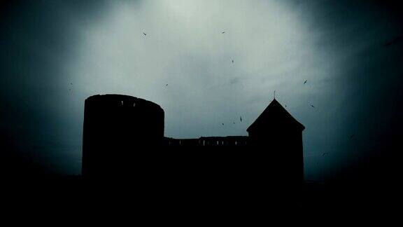黑暗城堡废墟的剪影与飞翔的黑鸟的时间流逝
