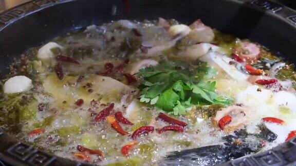 将滚烫的辣椒油倒入鱼汤和酸菜中缓慢的运动