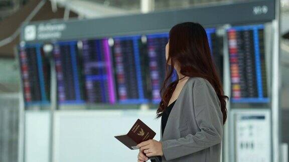 在机场持有护照的亚洲女性