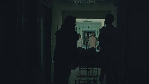 医生推着病床上的病人走过医院走廊