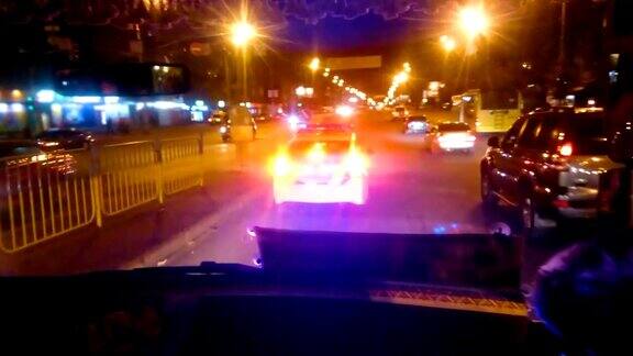 警察巡逻车夜间行驶在城市街道上执法者值班维护公共秩序