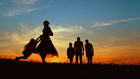 黄昏时分父亲带着两个儿子在草地上散步母亲在纺纱