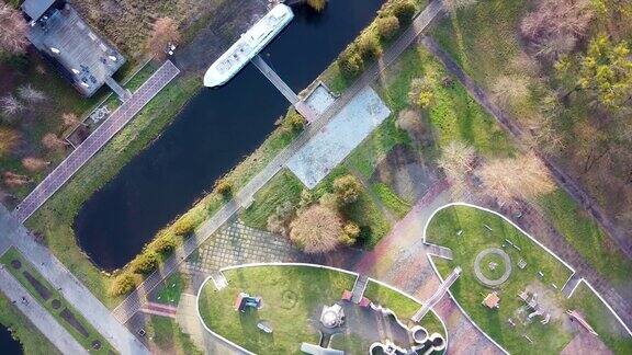 在阳光明媚的日子里无人机拍摄了一个有运河、停靠的船只和景观的公园