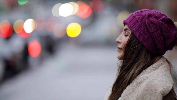 年轻女子在寒冷的城市街道等待她的朋友
