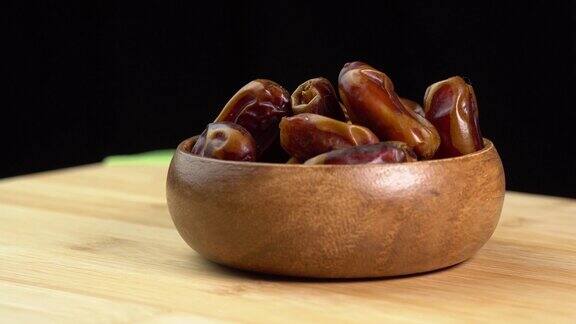 木碗里的枣子在木质背景上旋转旋转吃干果素食素食