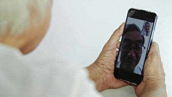 老年亚洲夫妇使用智能手机视频会议