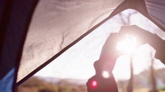 一个女人用手在帐篷上做心形的4k视频