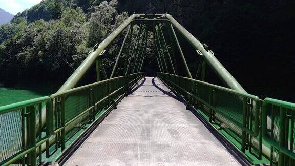 现代化的金属桥横跨在山间的河流上
