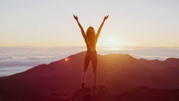 一个在山顶上欣赏日出的女人