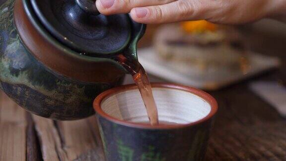 茶道把红茶从茶壶倒进杯子里