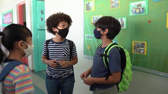 学生在学校走廊里说话戴着防护口罩