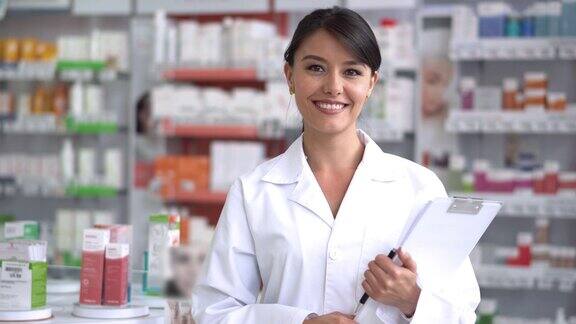 美丽的药剂师在一个药店看着镜头微笑