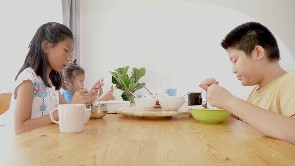 快乐的亚洲孩子在家里吃早餐一起聊天生活理念