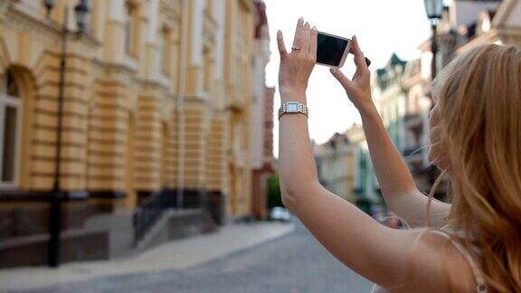 一名女子用手机拍摄建筑物