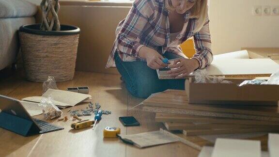 SLOMO女人在组装家具时拧紧螺丝