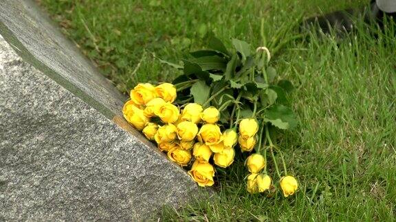 用手把鲜花放在坟墓上