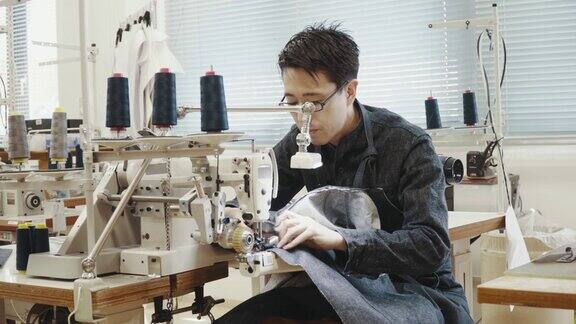 中等拍摄的中年裁缝工作缝纫机在他的设计工作室