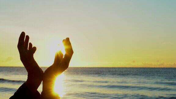 在日落背景下女人双手祈祷上帝的祝福