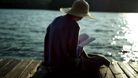 夏天放松在湖边码头上看书