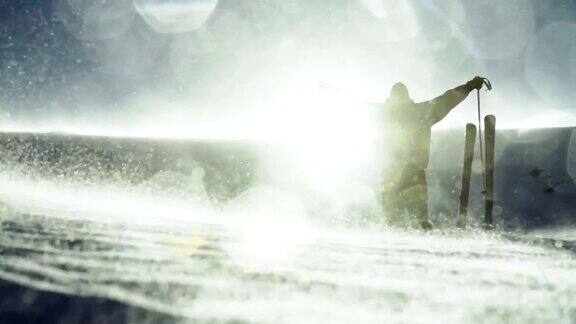 滑雪者举起双手山顶太阳耀斑