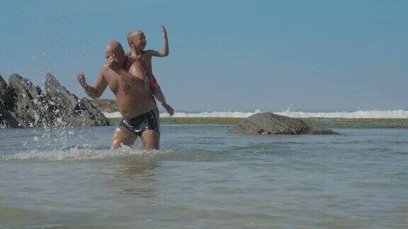 在蔚蓝的天空下爸爸和儿子在蔚蓝的海洋里玩耍