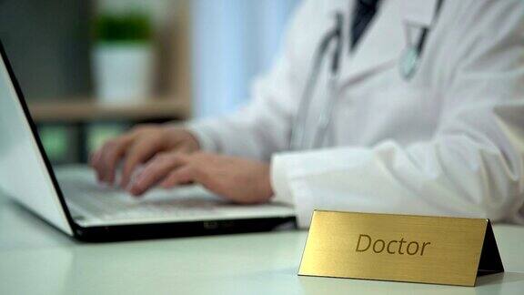 医生在笔记本电脑上输入诊断保存医疗记录咨询