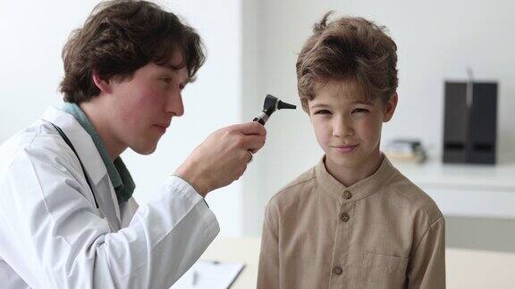 医生检查小男孩的耳朵并击掌示意