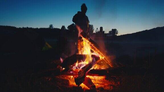 家庭露营大家庭在野外露营聚集在明亮的篝火旁