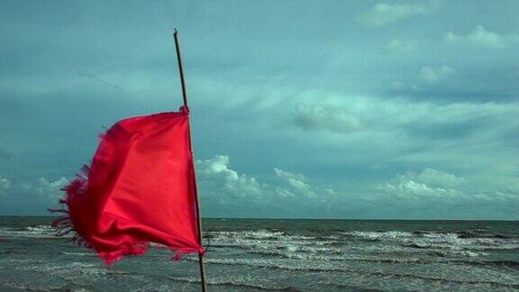 海面上挂着云和阳光的红旗危险警报