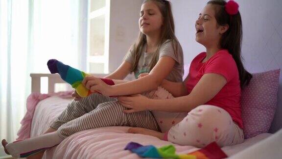 女孩帮助有特殊需要的姐姐在家穿袜子
