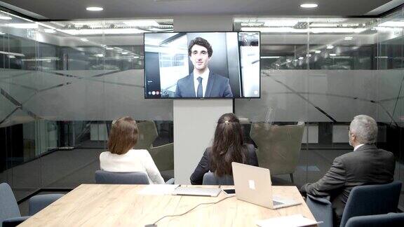 员工在视频会议中聆听年轻领导的讲话