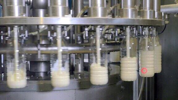 牛奶生产工厂用工业设备将牛奶倒入瓶中