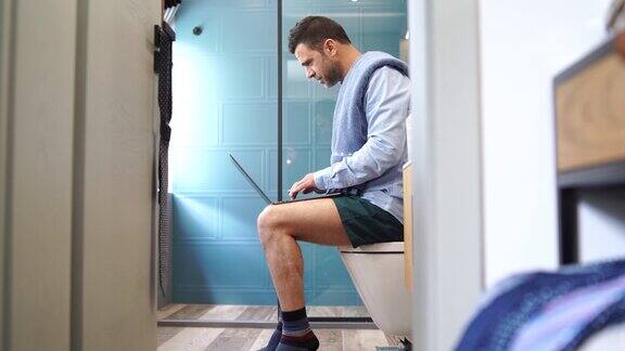 穿着内裤在家工作的4K视频商人在隔离期间在浴室里进行电话会议