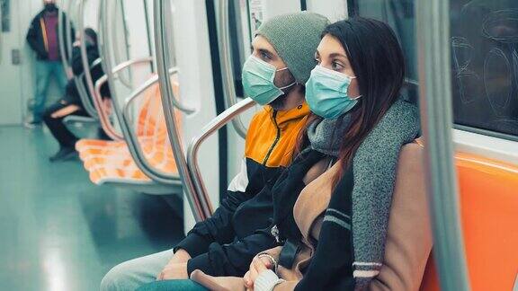 疫情期间的公共交通年轻夫妇戴着口罩乘坐地铁