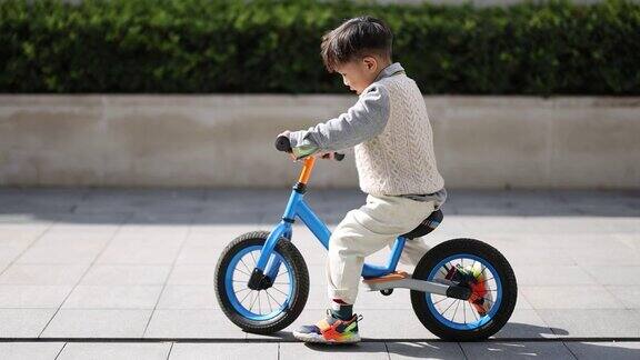 一个小男孩在学骑自行车