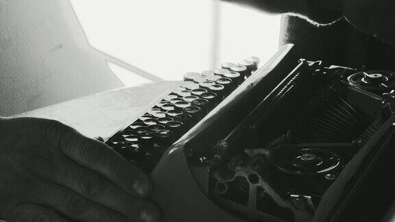 男人的手使用老式打字机浅景深和背光写书或者电影剧本画廊里的大范围打字机镜头