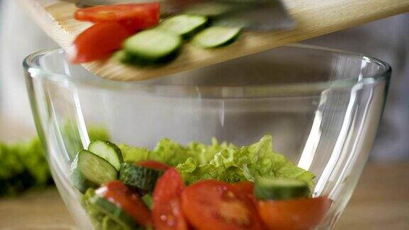 厨师将切碎的蔬菜与生菜一起放入碗中制作新鲜的维生素沙拉