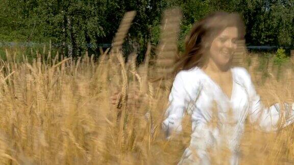年轻漂亮的女人穿着白衣带着麦子跑过田野